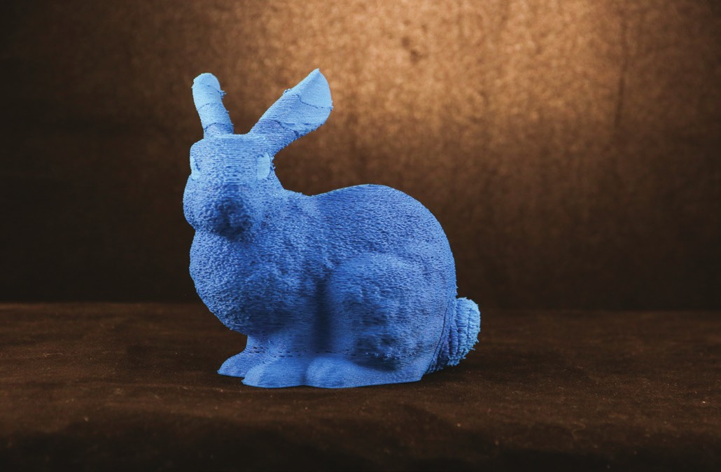Photograph of a blue printed bunny with a fuzzy textured surface, smoother ears, and a fuzzy tail.