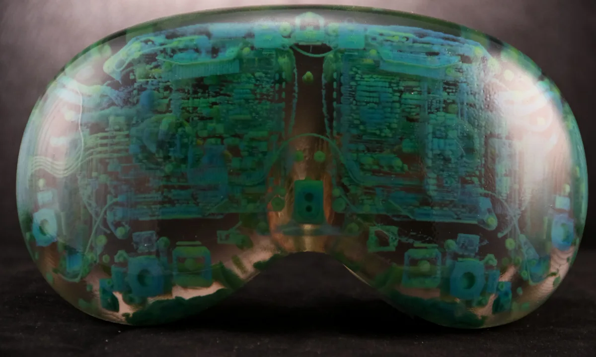 Front of the clear printed model of the headset, with internal circuit boards and components visible in green and copper tones.