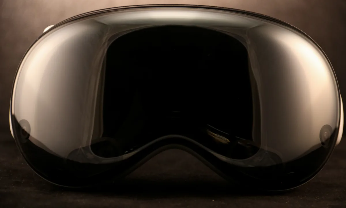 Front of an Apple Vision Pro headset with its dark, glossy glass.